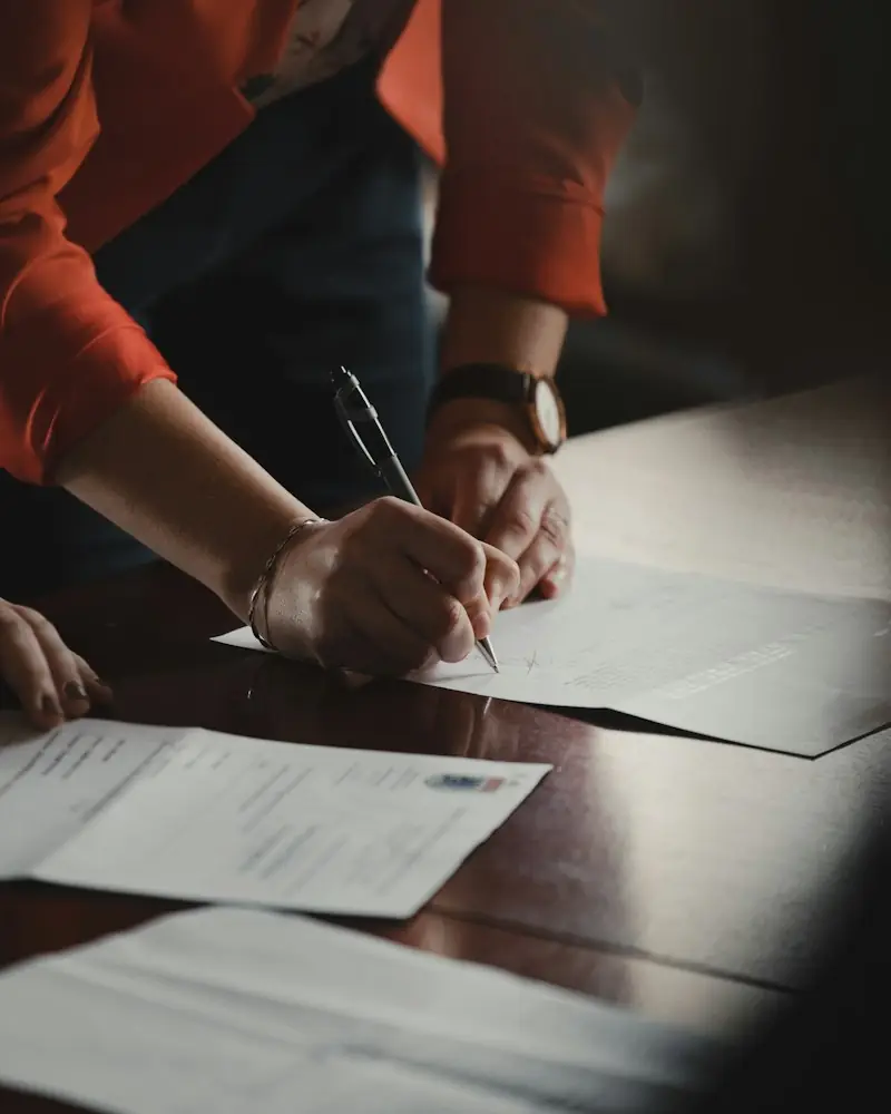 Mãos assinando um contrato sobre a mesa